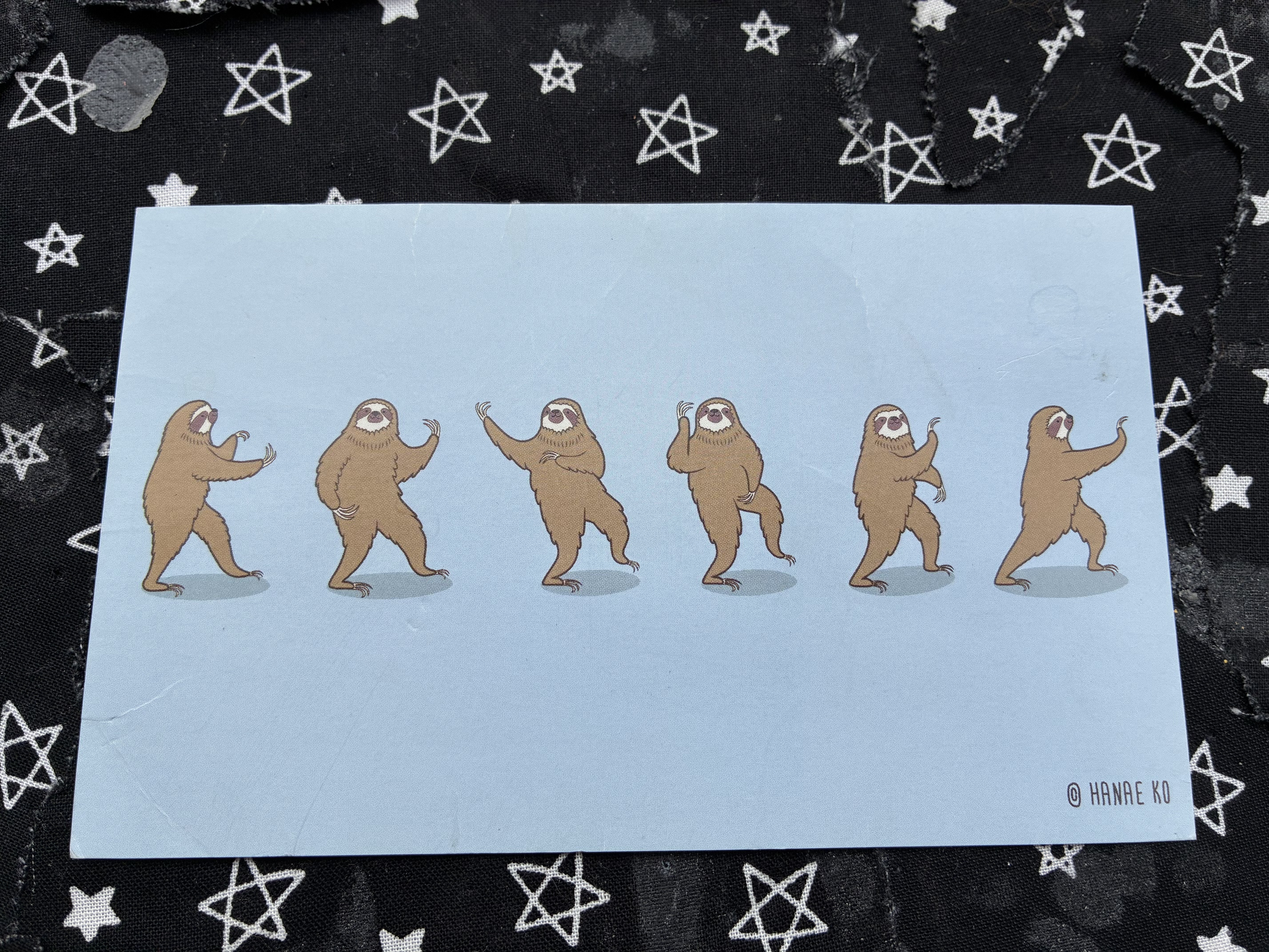 Postcard of sloths doing various tai chi poses.